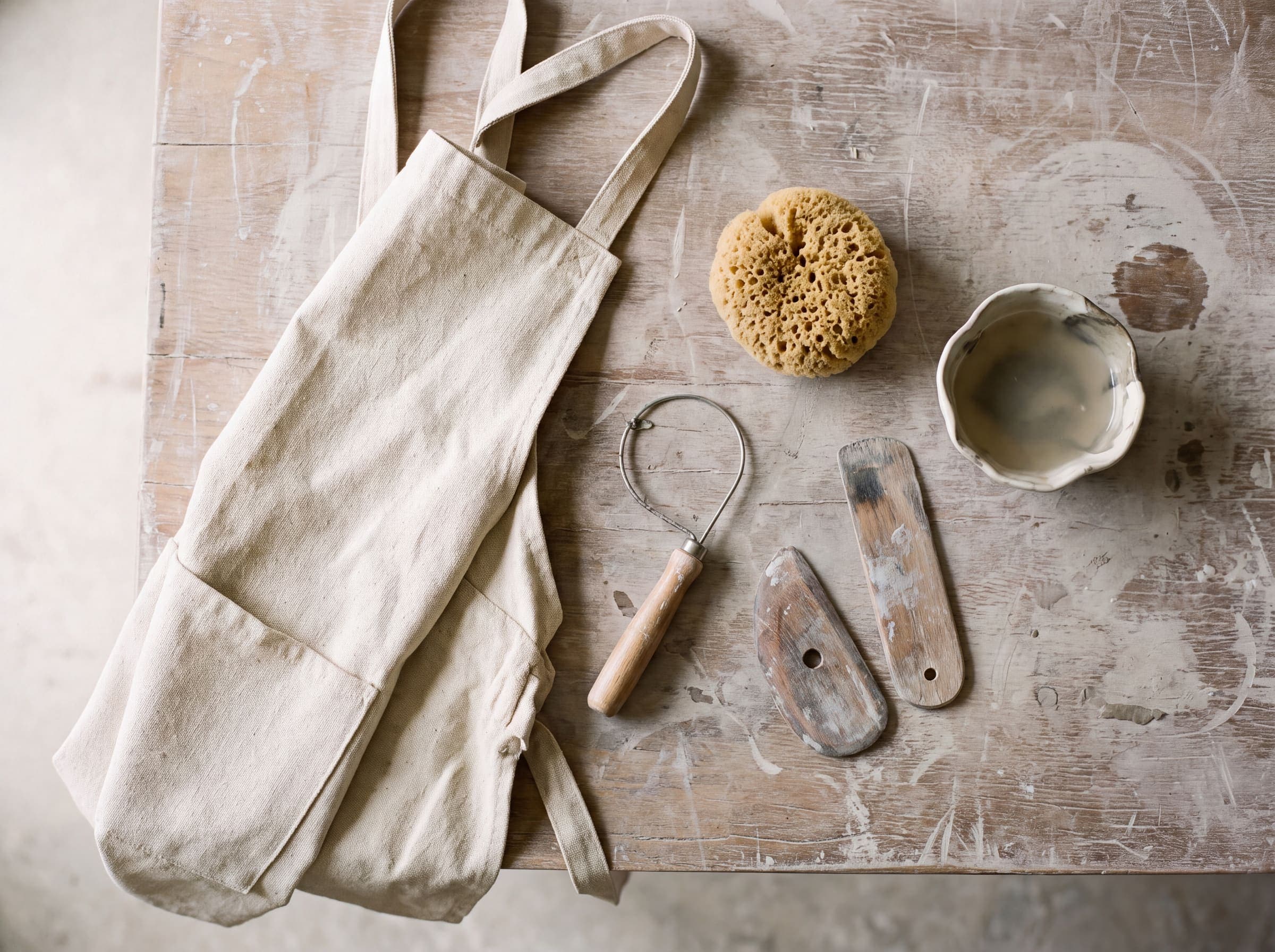 Aprons, wire cutters, ribs and sponges laid out on a work table